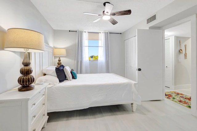 bedroom with baseboards, a ceiling fan, and visible vents