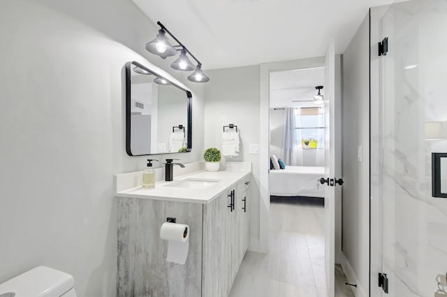ensuite bathroom featuring toilet, ensuite bath, vanity, and ceiling fan