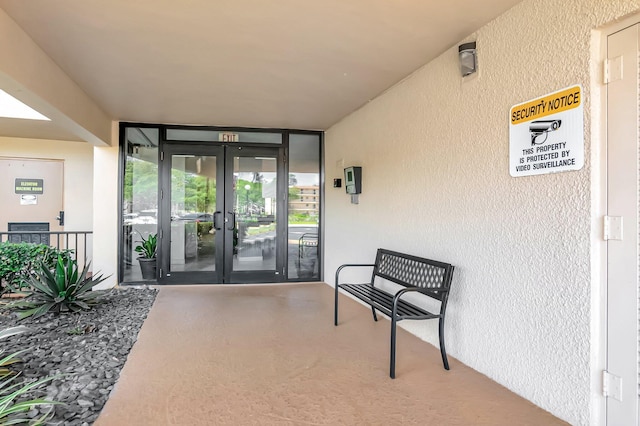 property entrance featuring stucco siding and french doors