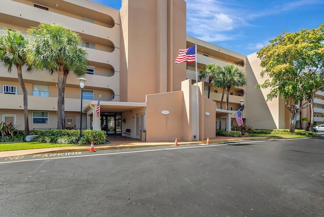 view of building exterior with uncovered parking