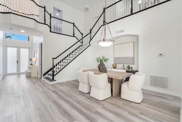 dining area featuring stairway, visible vents, light wood-style floors, and french doors