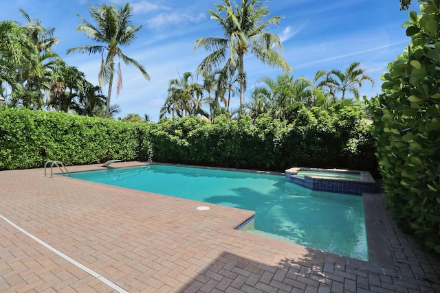 view of pool with a pool with connected hot tub and a fenced backyard