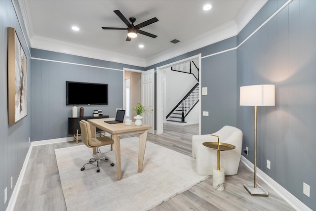 home office featuring light wood-style floors, ceiling fan, visible vents, and ornamental molding