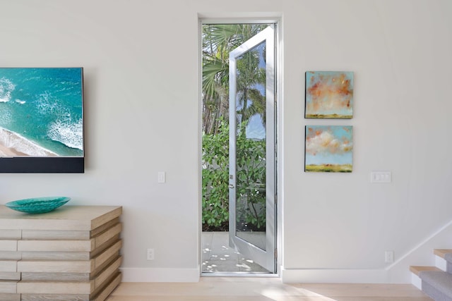 doorway featuring baseboards and stairs