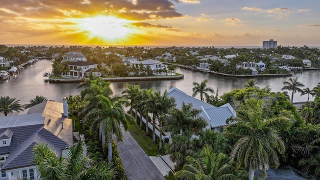 aerial view at dusk with a residential view and a water view