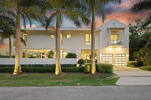 view of front of house with metal roof, a garage, and stucco siding