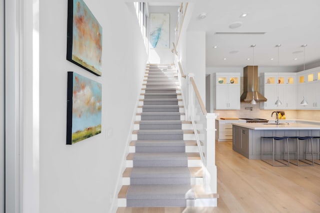 staircase featuring recessed lighting, baseboards, and wood finished floors