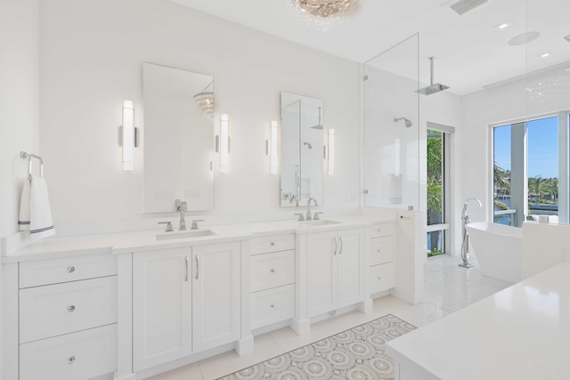 bathroom featuring vanity, visible vents, a soaking tub, a walk in shower, and tile patterned floors