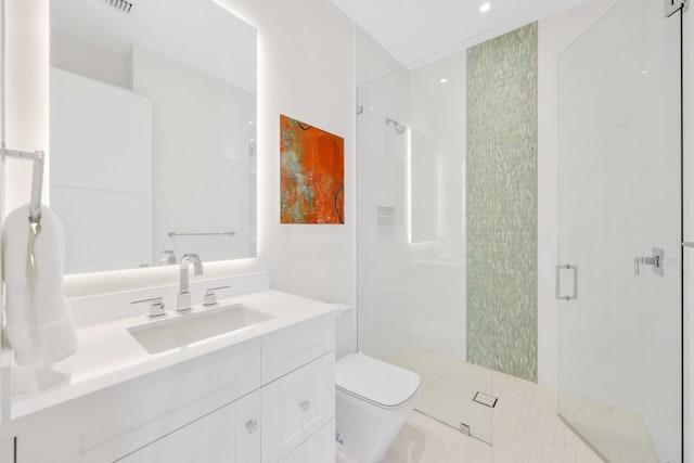 bathroom with vanity, toilet, and a stall shower