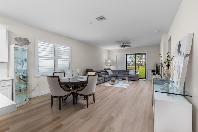 dining space with light wood-style floors, baseboards, visible vents, and a ceiling fan