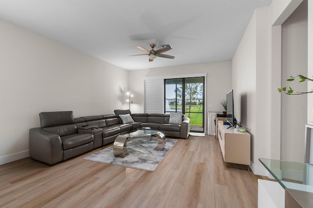 living room featuring light wood-type flooring, ceiling fan, and baseboards