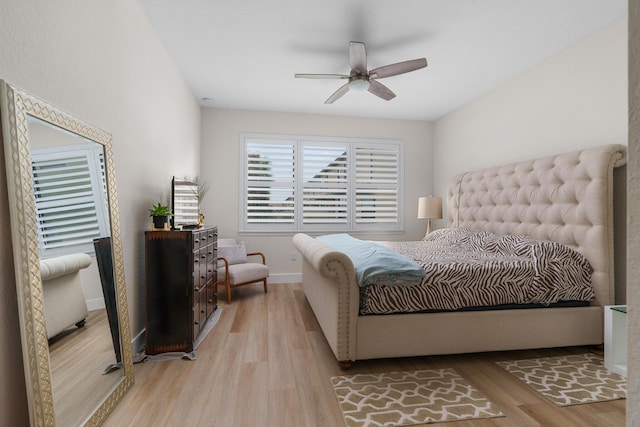 bedroom with light wood-style floors, ceiling fan, and baseboards