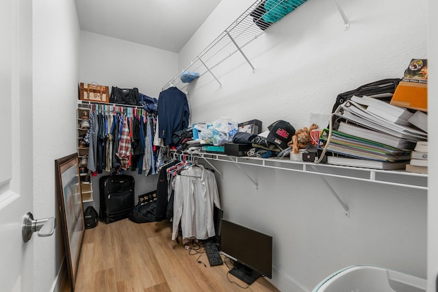 walk in closet with wood finished floors