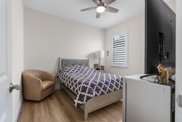 bedroom featuring ceiling fan, baseboards, and wood finished floors