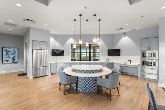 kitchen featuring gray cabinetry, visible vents, light countertops, appliances with stainless steel finishes, and a warming drawer