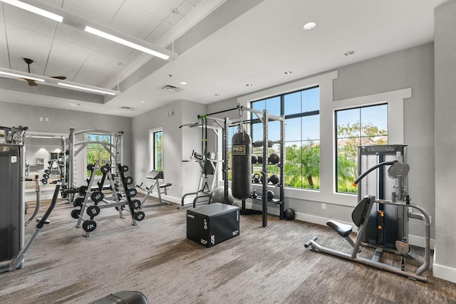 exercise room with carpet, visible vents, and baseboards