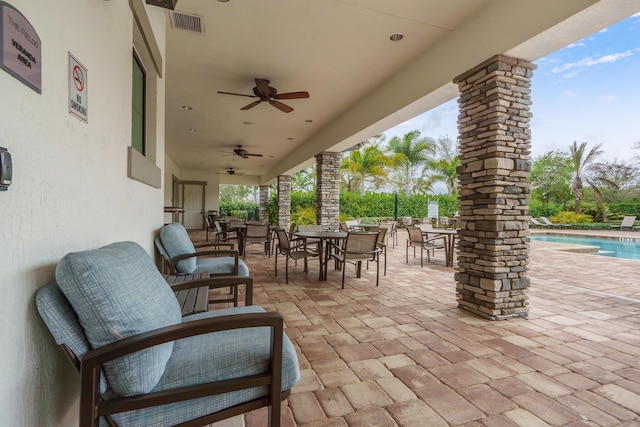 view of patio featuring ceiling fan, outdoor dining area, visible vents, and an outdoor pool