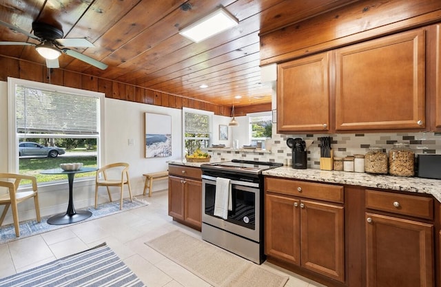 kitchen with light stone counters, wood ceiling, stainless steel range with electric cooktop, brown cabinets, and tasteful backsplash