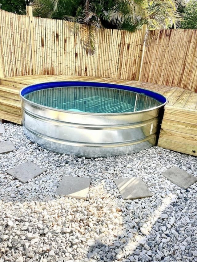 view of pool featuring fence and a wooden deck