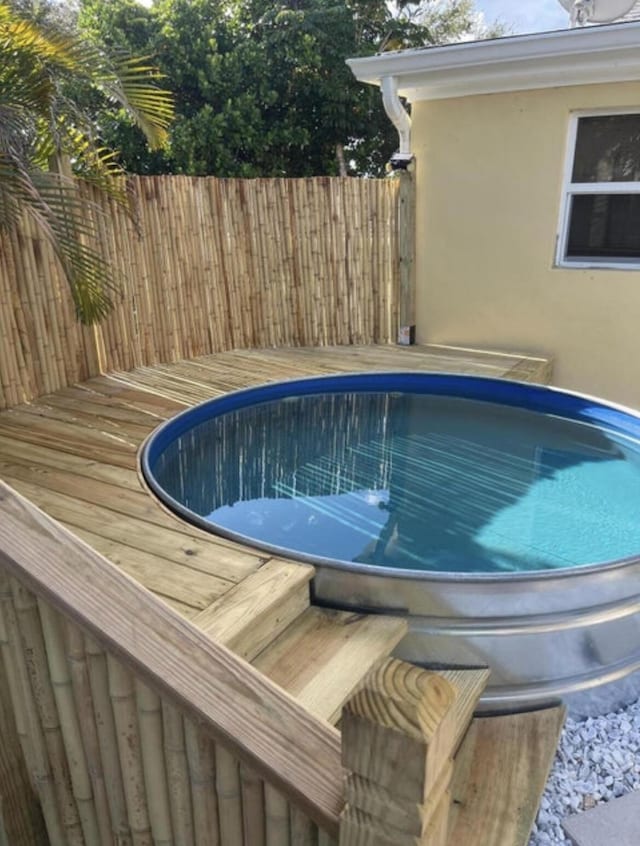 view of pool with fence and a deck