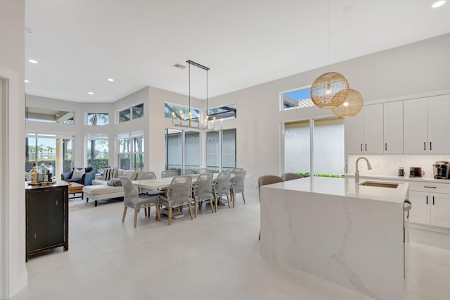 dining area with an inviting chandelier, a high ceiling, visible vents, and recessed lighting