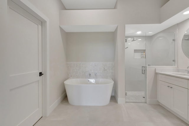 bathroom featuring a freestanding tub, vanity, tile walls, a shower stall, and tile patterned floors