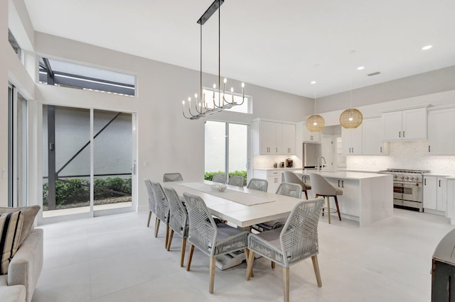 dining area featuring recessed lighting, a notable chandelier, and a high ceiling