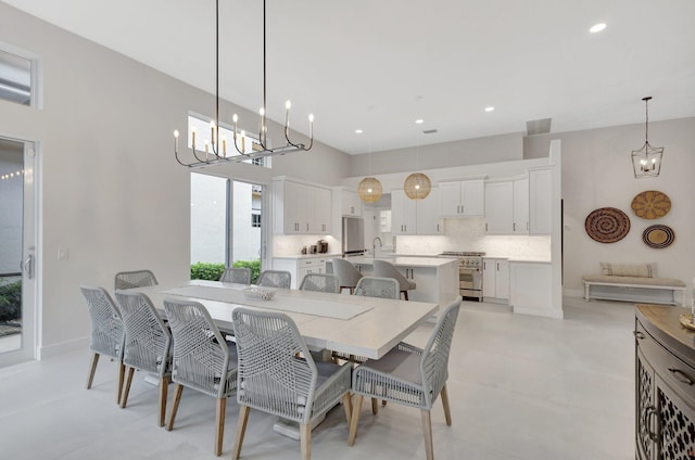 dining room with an inviting chandelier, baseboards, and recessed lighting