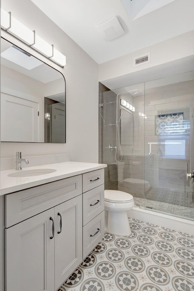 bathroom featuring visible vents, toilet, tile patterned floors, vanity, and a shower stall