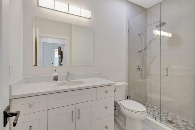 bathroom featuring toilet, a shower stall, and vanity