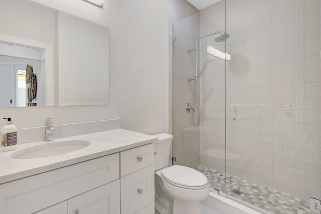 bathroom featuring vanity, a shower stall, and toilet