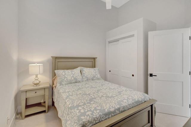 bedroom featuring light tile patterned floors, baseboards, and a closet