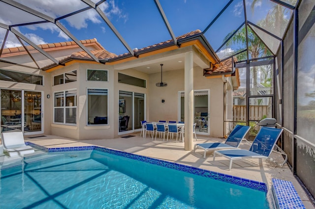 outdoor pool with glass enclosure and a patio area