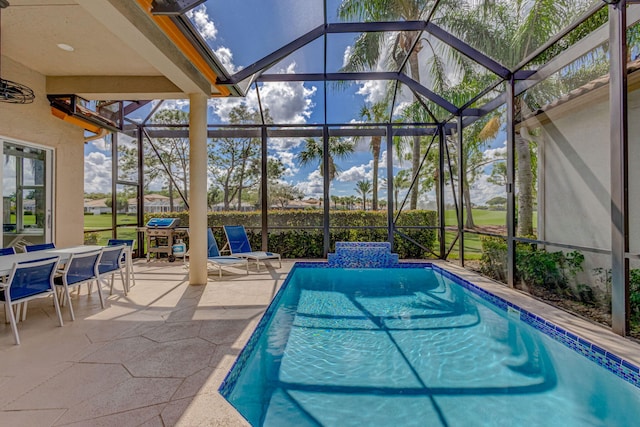 pool featuring glass enclosure and a patio area