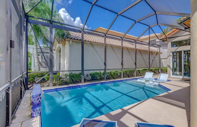 outdoor pool with a lanai and a patio area