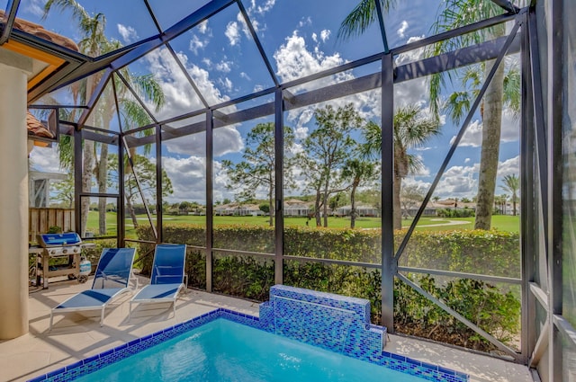 outdoor pool with glass enclosure, a patio, and grilling area