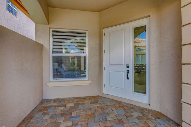 entrance to property featuring a patio and stucco siding