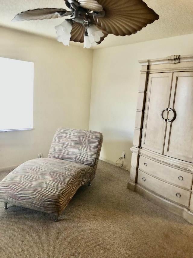 living area featuring ceiling fan and carpet