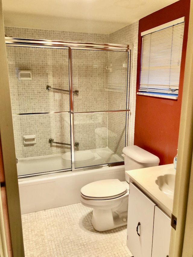 full bath featuring enclosed tub / shower combo, vanity, toilet, and tile patterned floors