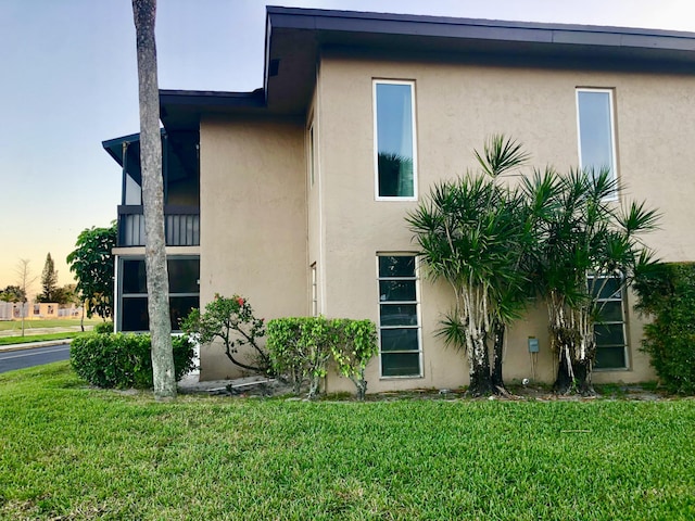 view of home's exterior featuring a lawn and stucco siding