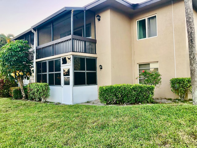 view of property exterior featuring a lawn and stucco siding