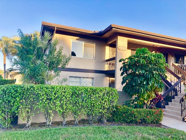 exterior space with stairway and stucco siding