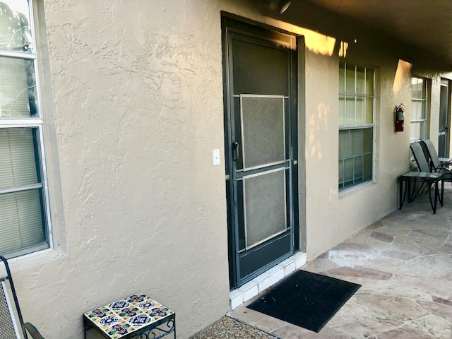 property entrance with stucco siding