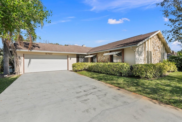 single story home featuring a garage, driveway, a front lawn, and stucco siding