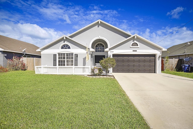 ranch-style house featuring driveway, fence, a front lawn, and stucco siding