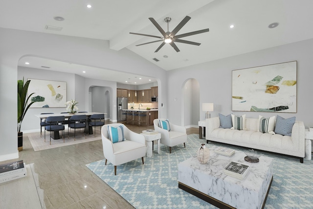 living room with arched walkways, lofted ceiling with beams, recessed lighting, and baseboards