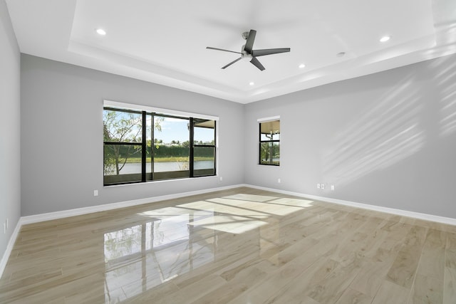 unfurnished room featuring a tray ceiling, baseboards, and recessed lighting