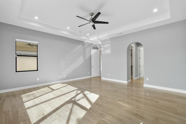 unfurnished room featuring arched walkways, ceiling fan, recessed lighting, baseboards, and light wood finished floors