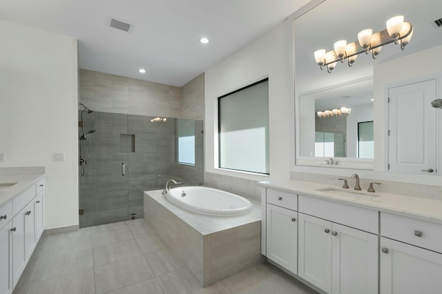 bathroom with a garden tub, two vanities, a sink, visible vents, and a stall shower