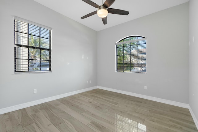 unfurnished room with light wood-style floors, baseboards, and a ceiling fan